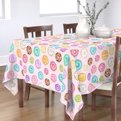 Scattered Rainbow Donuts on pale spotty pink - large scale