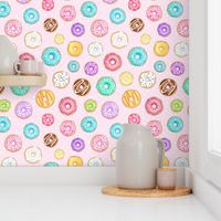 Scattered Rainbow Donuts on pale spotty pink - large scale