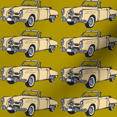 Cream 1950 Studebaker convertible on mustard green background