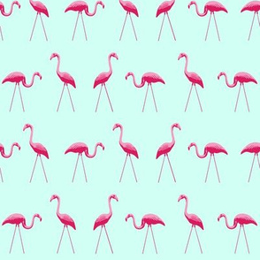tiny pink plastic flamingos in a row on mint