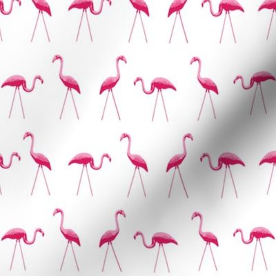 tiny pink plastic flamingos in a row on white