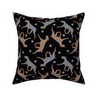 Trotting dilute Doberman Pinschers and paw prints - black