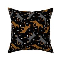 Trotting uncropped Doberman Pinschers and paw prints - black