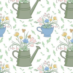 wild flowers in watering cans and cups 