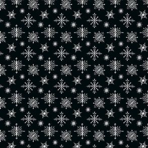 White hand-drawn snowflakes on black