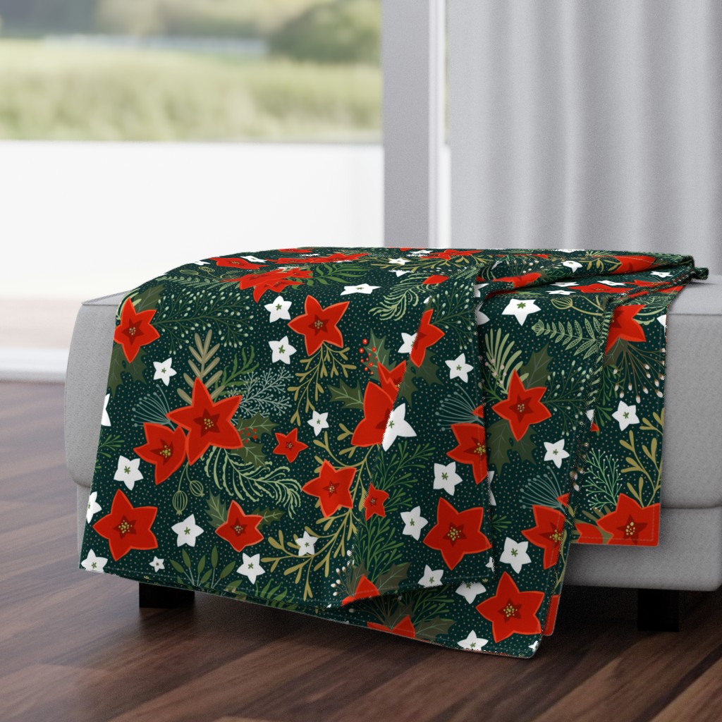 Poinsettia and holly leaves with red berries on dark green