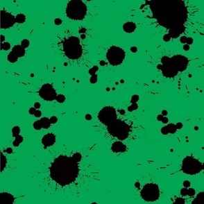 Black ink paint splatters on jewel green