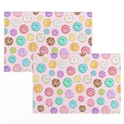 Scattered Rainbow Donuts on pale pink spotty - medium scale