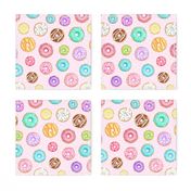 Scattered Rainbow Donuts on pale pink spotty - medium scale