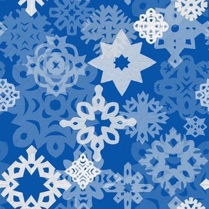 Paper snowflakes and stars on indigo background