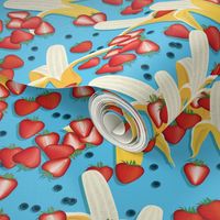 Bananas, strawberries, blueberries on a light blue background