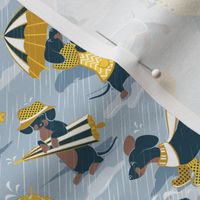 Tiny scale // Ready For a Rainy Walk // pastel blue background navy blue dachshunds dogs with yellow and transparent rain coats and umbrellas