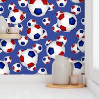 Red white and blue soccer balls on blue - large