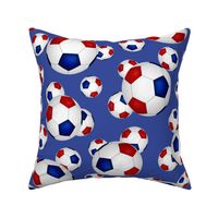 Red white and blue soccer balls on blue - large