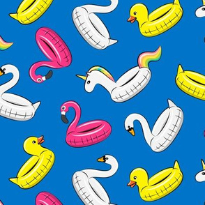 pool floats (swan, flaming, duck, unicorn) on blue