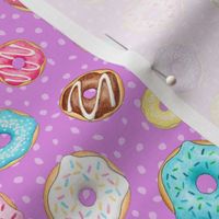 Scattered Rainbow Donuts on bright purple spotty