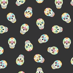 Scattered Calavera Sugar Skulls on black night - small scale