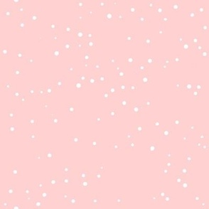 White abstract freely placed polka dots on a pale cute baby pink background