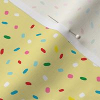 glazed with colorful sprinkles on yellow melting icing seamless pattern