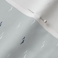 Tiny white and navy seagulls on cool grey