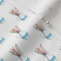 Knitting Needles in Vase on white background