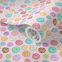 Scattered Rainbow Donuts on pale pink spotty - small scale